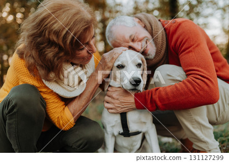 Senior couple walking dog in autumn forest. Senior couple walking dog in autumn forest. 131127299
