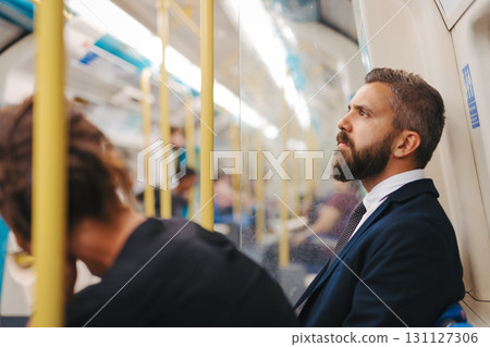 Side view of man sitting in subway train, travelling to work. 131127306