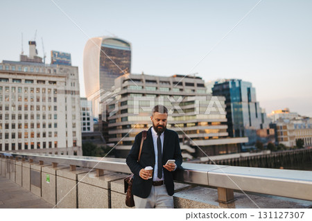 Handsome businessman looking at smartphone, waiting for someone. Handsome businessman looking at smartphone, waiting for someone. 131127307