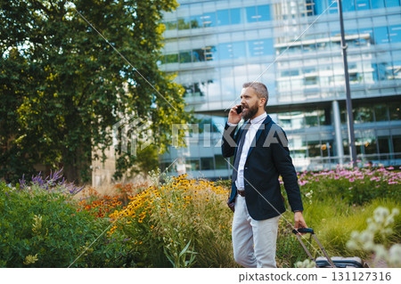 Handsome businessman with smartphone in the city, making a phone call. Handsome businessman with smartphone in the city, making a phone call. 131127316
