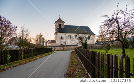 A serene view of the Church of the Nativity of the Virgin Mary in the village of Mlynicky Dvur, showcasing its architectural beauty and peaceful rural surroundings A serene view of the Church of the Nativity of the Virgin Mary in the village of Mlynicky Dvur, showcasing its architectural beauty and peaceful rural surroundings 131127376