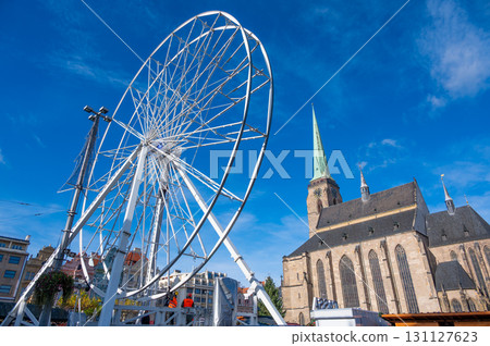 A stunning view of the Ferris wheel in the square in front of St. Bartholomew's Cathedral in Pilsen, adorned with festive lights during the Christmas markets. 131127623