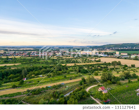 A stunning drone view of Hrusovany u Brna, showcasing the charming town, surrounding vineyards, and a distant, scenic view of the Palava Hills. 131127641