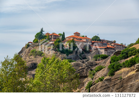 Monastery Meteora Greece. Stunning summer panoramic landscape. View at mountains and green forest against epic blue sky with clouds. UNESCO heritage list object. 131127872