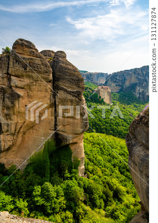 Monastery Meteora Greece. Stunning summer panoramic landscape. View at mountains and green forest against epic blue sky with clouds. UNESCO heritage list object. 131127874