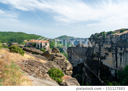 Monastery Meteora Greece. Stunning summer panoramic landscape. View at mountains and green forest against epic blue sky with clouds. UNESCO heritage list object. 131127883