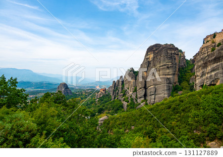 Monastery Meteora Greece. Stunning summer panoramic landscape. View at mountains and green forest against epic blue sky with clouds. UNESCO heritage list object. 131127889