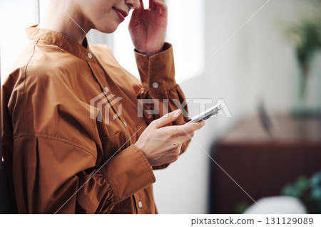 一位女士的手在窗邊操作智慧型手機 一位女士的手在窗邊操作智慧型手機 131129089