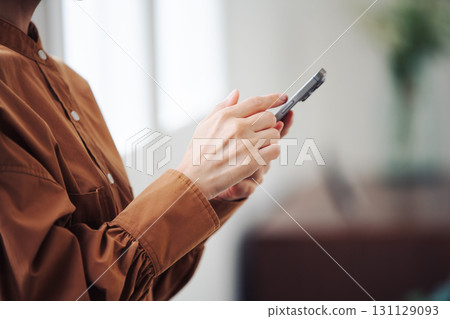 一位女士的手在窗邊操作智慧型手機 一位女士的手在窗邊操作智慧型手機 131129093