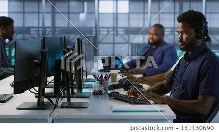 Technician entering data center, tuning music on and starting work on AI predictive maintenance systems. Server hub staff member using artificial intelligence to identify hardware failures, camera A 131130690