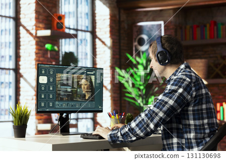 Man in home office uses artificial intelligence to generate compelling videos from basic text prompts. Person uses AI GPT generating clips using computer vision and natural language processing 131130698