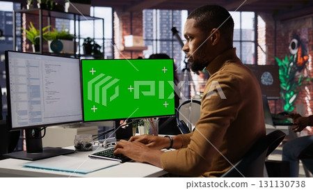 Programmer coding in startup office using green screen PC, building scalable solutions for businesses. AI industry startup technician leverages machine learning technology on mockup computer, camera B 131130738