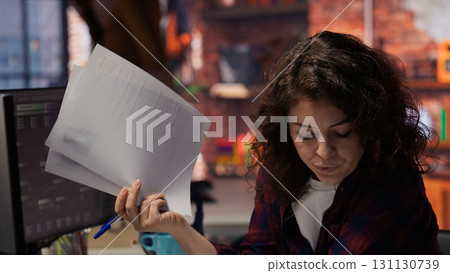 Tech startup HR employee analyzing candidates for job opening, reviewing resumes to determine skills. Woman screening people for software development Silicon Valley company position, camera B 131130739