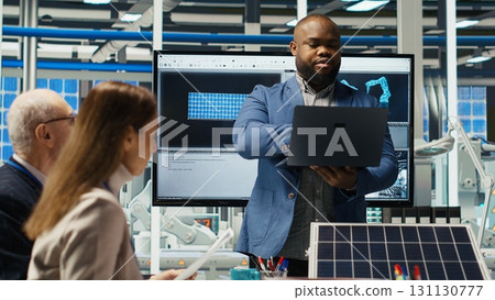 Shareholders reading documents, discussing investment opportunities in clean energy manufacturing. Executives in solar panels plant office reviewing solar technology paperwork reports, camera B Shareholders reading documents, discussing investment opportunities in clean energy manufacturing. Executives in solar panels plant office reviewing solar technology paperwork reports, camera B 131130777