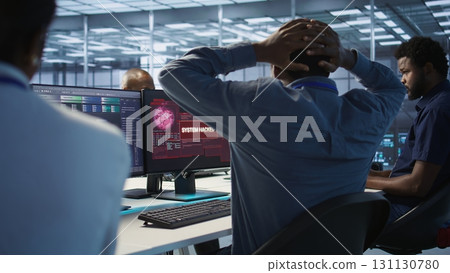 Cybersecurity team monitoring security incidents, alerted by security breach alert, working together to get rid of virus, protecting infrastructure from threats, camera A 131130780