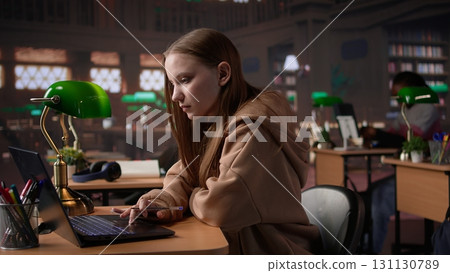 University student does research on foreign affairs via primary source materials and academic resources to create an assignment. Girl working hard for a scholarship and diploma. Camera B. University student does research on foreign affairs via primary source materials and academic resources to create an assignment. Girl working hard for a scholarship and diploma. Camera B. 131130789