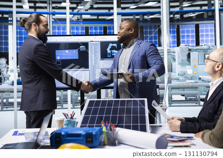 Photovoltaics factory manager meeting with investor to present automation technology, doing handshake. Solar panels plant executive shaking hands with shareholder interested in manufacturing process 131130794