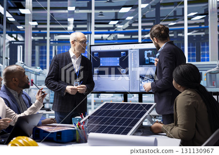Factory executives discuss solar panel research and development strategies, analyzing prototypes and automation processes to enhance sustainable manufacturing and industrial innovation Factory executives discuss solar panel research and development strategies, analyzing prototypes and automation processes to enhance sustainable manufacturing and industrial innovation 131130967