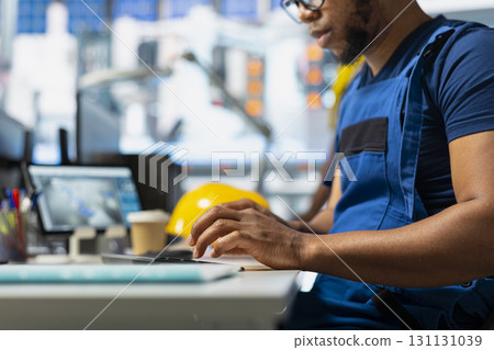 Photovoltaics male employee analyzing performance data on computer and optimizing efficiency. Solar panel factory engineer working on solar cells design prototype, innovative production. 131131039