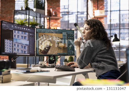 Woman developer works on an interior design project using CAD software to create a detailed floor plan, virtual assets. Graphic designer uses digital tool to configure room and arrangements. 131131047