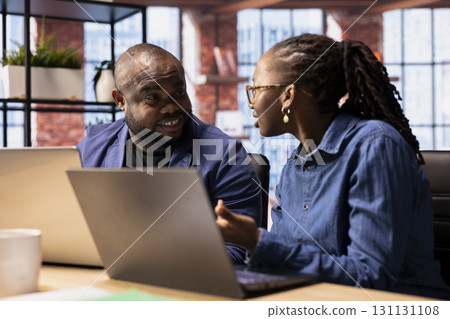 Dissatisfied woman expressing her concerns to her partner and getting angry, having an argument and being displeased with their work. African american boyfriend and girlfriend doing mistakes. 131131108