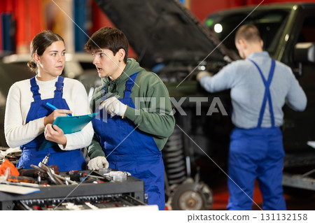 Woman discussing car repair plan with mechanic 131132158
