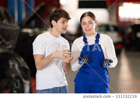 guy consults with a car service worker guy consults with a car service worker 131132219
