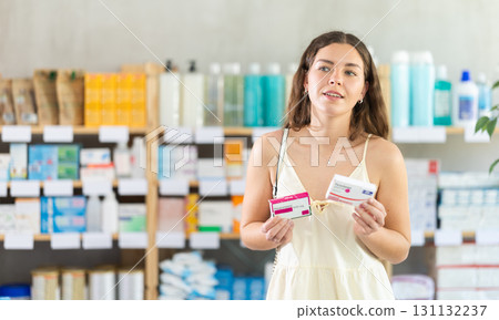 Young woman buys paracetamol pills at pharmacy Young woman buys paracetamol pills at pharmacy 131132237