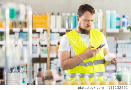 Male builder scans code on package of pills to check expiration date 131132261