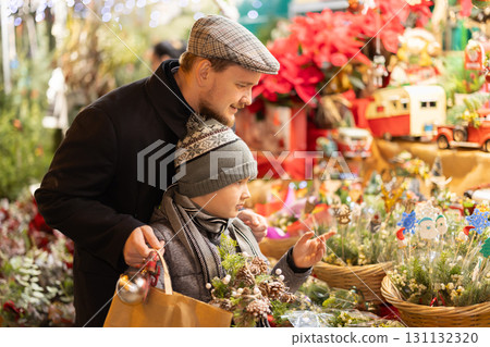 Young dad and son choose spruce bouquets Young dad and son choose spruce bouquets 131132320