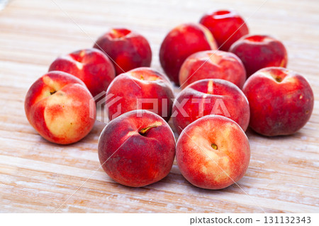 Delicious ripe peaches fruit on wooden surface in kitchen 131132343