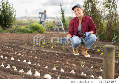 Female farmer planting seeds in the garden Female farmer planting seeds in the garden 131132367