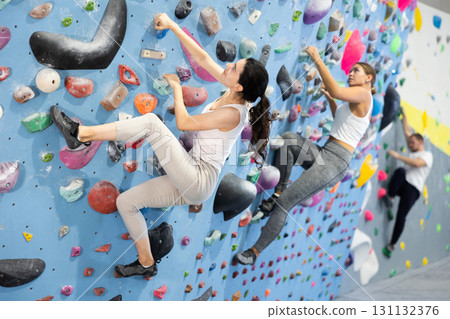 Young woman doing rock climbing on climbing wall Young woman doing rock climbing on climbing wall 131132376