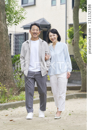 中年夫婦在戶外手挽手散步，全身 131132386