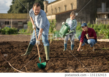 Male farmer with shovel dripping garden Male farmer with shovel dripping garden 131132413
