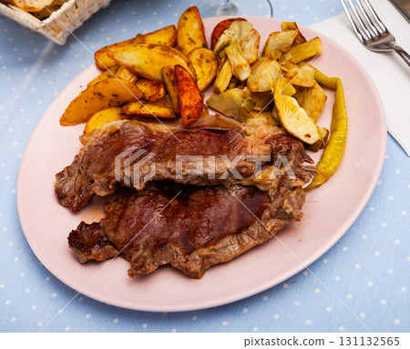 Tasty baked beef steak with potatoes and artichokes 131132565