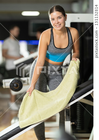 Girl puts towel on simulator and prepares equipment for training. 131132814