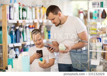 Dad and son scan barcode on packaging of liquid hand soap Dad and son scan barcode on packaging of liquid hand soap 131132829
