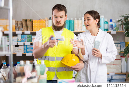 male builder chooses an ointment in a pharmacy male builder chooses an ointment in a pharmacy 131132834