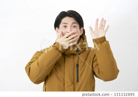 A man wearing a down jacket is surprised on a white background A man wearing a down jacket is surprised on a white background 131132895