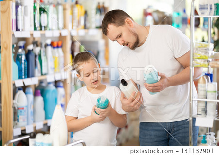 Man and boy choosing shampoo or shower gel in store Man and boy choosing shampoo or shower gel in store 131132901