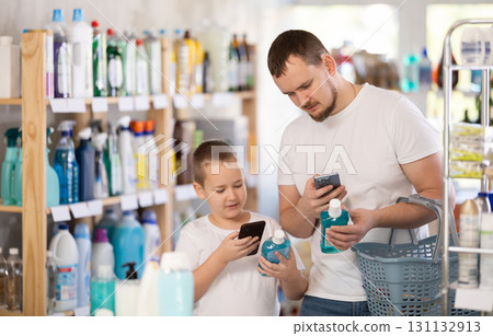 Dad and son scan barcode on packaging of mouthwash Dad and son scan barcode on packaging of mouthwash 131132913