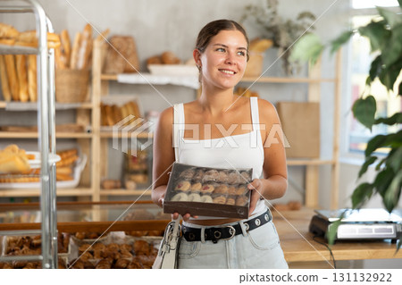 Young woman with box of cookies in bakery 131132922