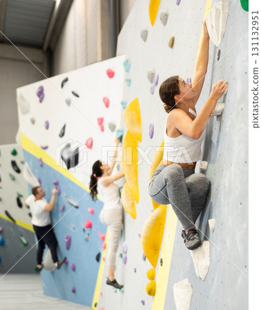 Young woman practicing rock climbing on climbing wall Young woman practicing rock climbing on climbing wall 131132951