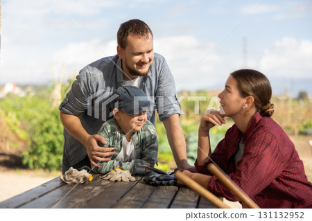 Man woman and boy talking while harvesting Man woman and boy talking while harvesting 131132952
