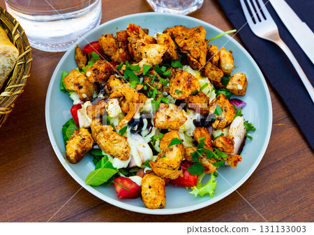 Popular dish of American cuisine is a warm Caesar salad with fried chicken and champignons 131133003