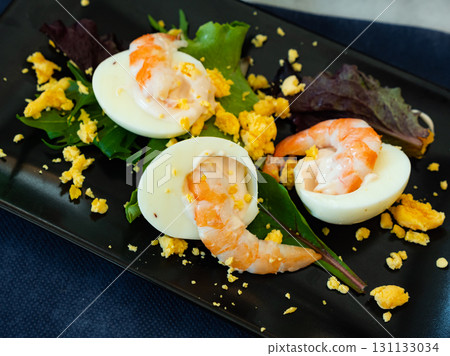 Huevos mimosa con gambas, eggs with prawns and salad Huevos mimosa con gambas, eggs with prawns and salad 131133034