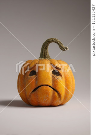 Realistic Carved Pumpkin with Sad Expression on Gray Background Realistic Carved Pumpkin with Sad Expression on Gray Background 131133427
