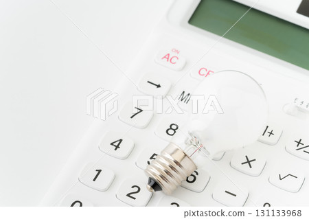 Close-up of a light bulb on top of a calculator Close-up of a light bulb on top of a calculator 131133968