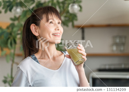 中年女性喝冰沙和蔬菜汁來保持健康 中年女性喝冰沙和蔬菜汁來保持健康 131134209